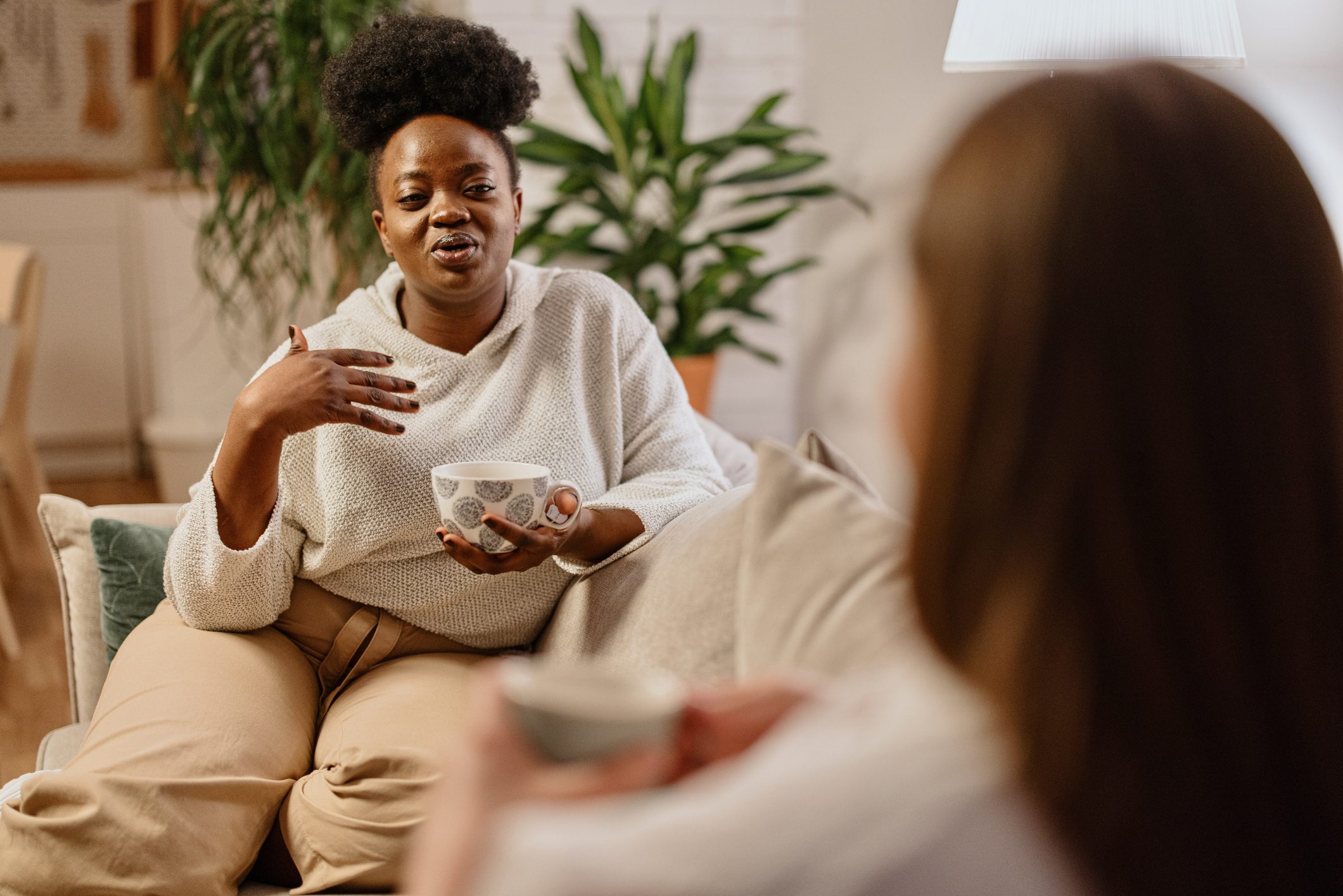 Two woman on the couch talking.