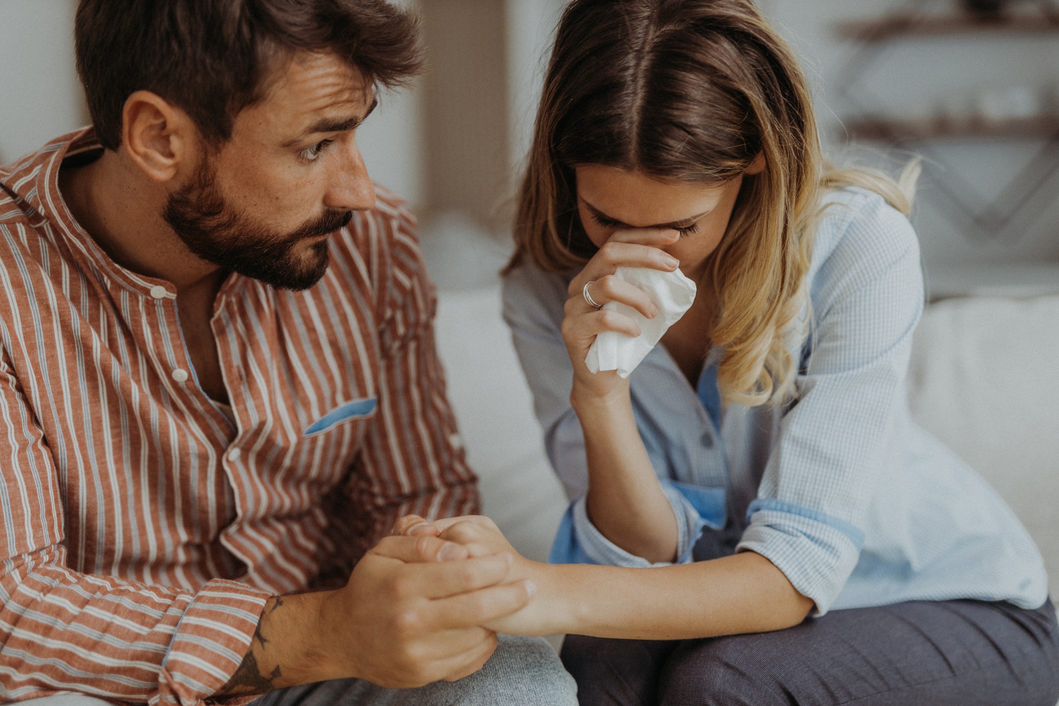 A man comforting a upset woman.