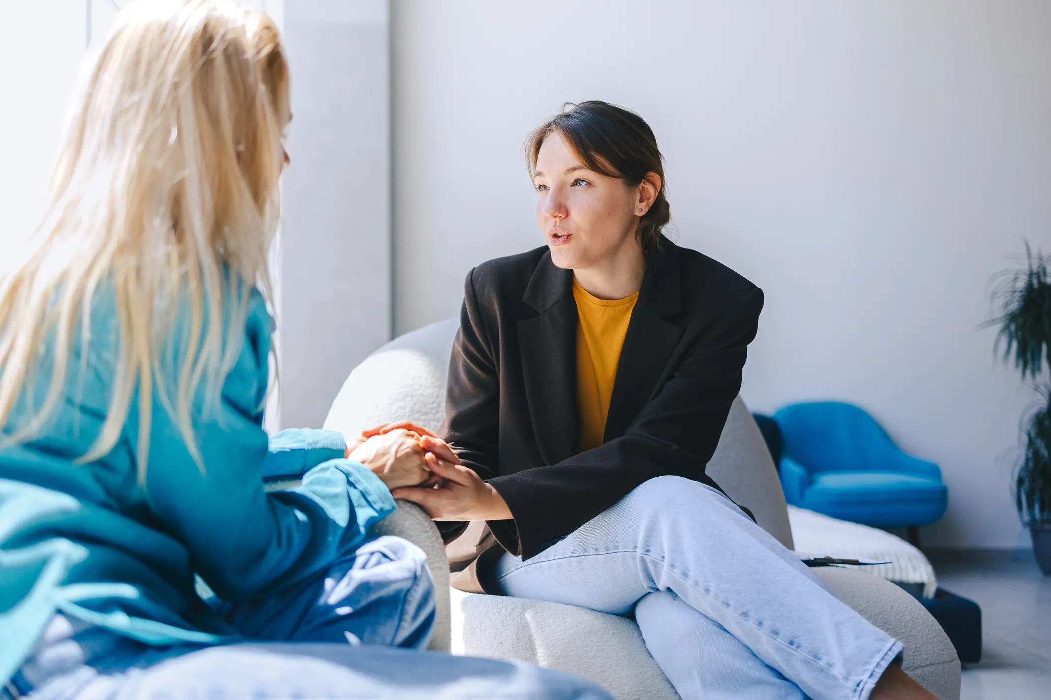 Two women sitting in armchairs and talking.